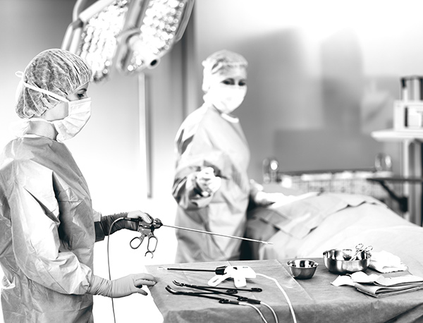 A nurse hands the doctor the BiClamp in the operating room.